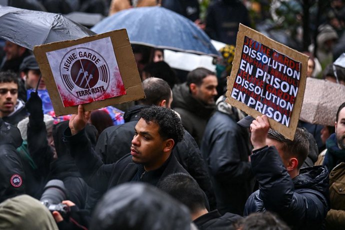 15 de fevereiro de 2026, Paris, Ilha de França (Região, França: Ativistas seguram cartazes exigindo a dissolução da Jovem Guarda... Reunião de políticos e militantes de extrema direita na Place de la Sorbonne para prestar homenagem a Quentin, que foi espa
