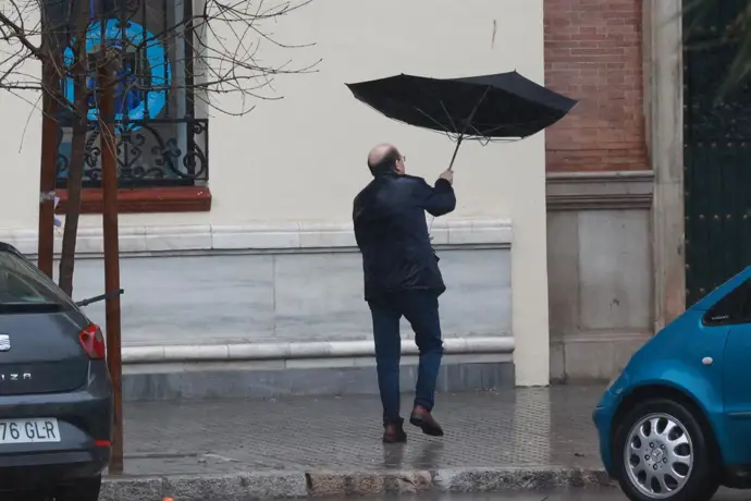 Una persona se protege de la lluvia con su paraguas