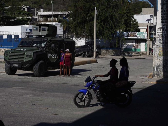 Un vehículo blindado de las fuerzas de seguridad y algunos transeúntes cerca de la intersección del aeropuerto, mejor conocida como la intersección de Rezistans, en Puerto Príncipe, capital de Haití