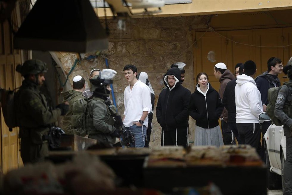 Soldados israelíes y un grupo de colonos judíos en la ciudad de Hebrón, en Cisjordania