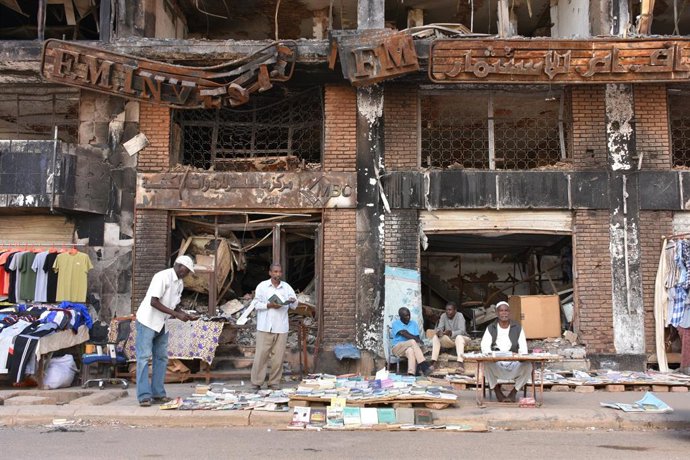 03 February 2026, Sudan, Khartoum: People are selling goods in front of a damaged building in Khartoum. Normality is gradually returning to the Sudanese capital Khartoum following the return of the government. Many refugees have returned and stores and ma