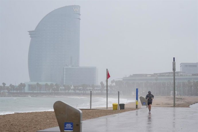 Archivo - Un hombre practica surf durante el temporal, a 19 de enero de 2026, en Barcelona, Cataluña (España). 