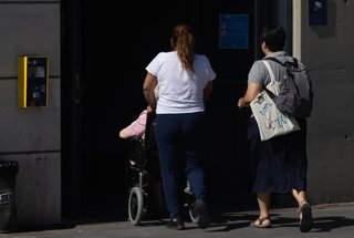 Archivo - Una mujer empuja a una persona en silla de ruedas,