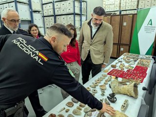 Un agente de la Unidad de Policía Nacional Adscrita muestra las piezas arqueológicas intervenidas en Almería.