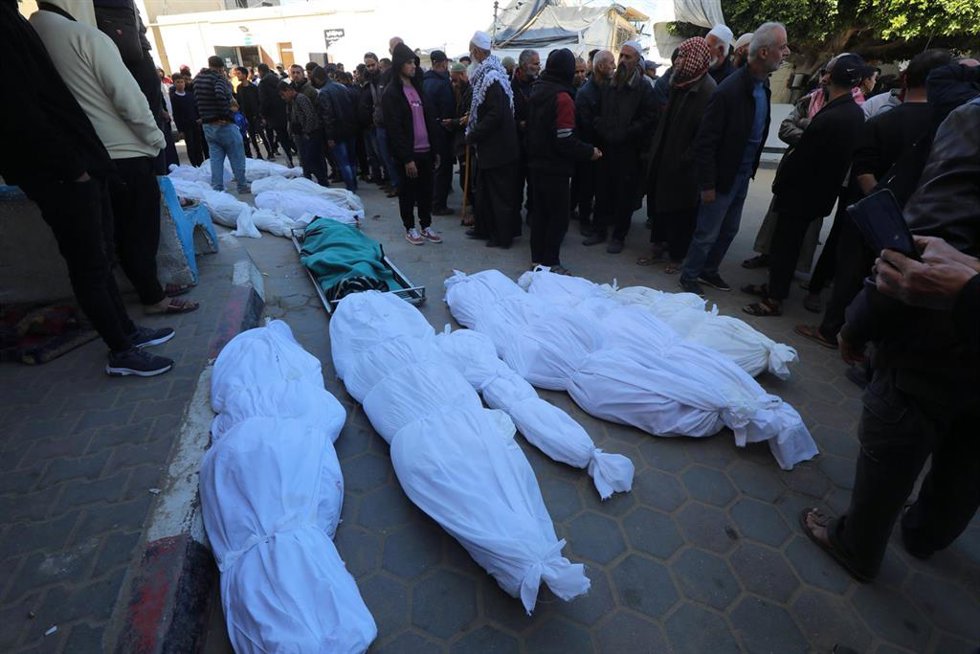Archivo - Palestinos junto a varios muertos por la ofensiva de Israel contra la Franja de Gaza (archivo)