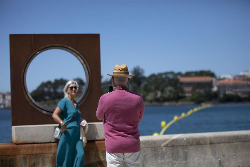 Archivo - Un hombre echa una foto a una mujer en el paseo marítimo de la playa de Sanxenxo, a 4 de junio de 2021, en Sanxenxo, Pontevedra, Galicia, (España). 