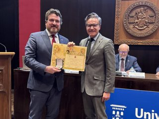 El decano del ReICAZ, Alfredo Sánchez-Rubio, recibe el reconocimiento de la medalla de socio de honor colectiva de la Asociación Los Sitios de manos del consejero municipal Víctor Serrano.