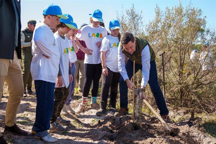 El presidente de la Junta de Andalucía, Juanma Moreno, participa en una plantación de árboles en Las Peñuelas, en Doñana,  junto a escolares dentro de una iniciativa del Laboratorio de Acción para los Bosques y la Biodiversidad.