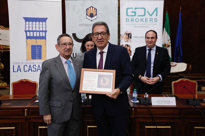 Antonio Pulido (centro) muestra su nombramiento como embajador de la Cofradía Gastronómica del Rabo de Toro Cordobés, tras entregárselo Ricardo Rojas (izda.).