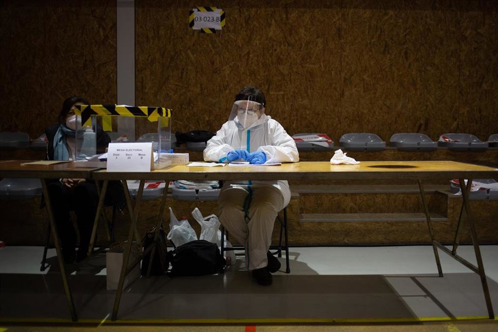 Archivo - Una mujer con un EPI en una mesa electoral del Polideportivo Tres Xemeneies en Barcelona, Cataluña (España), a 14 de febrero de 2021.