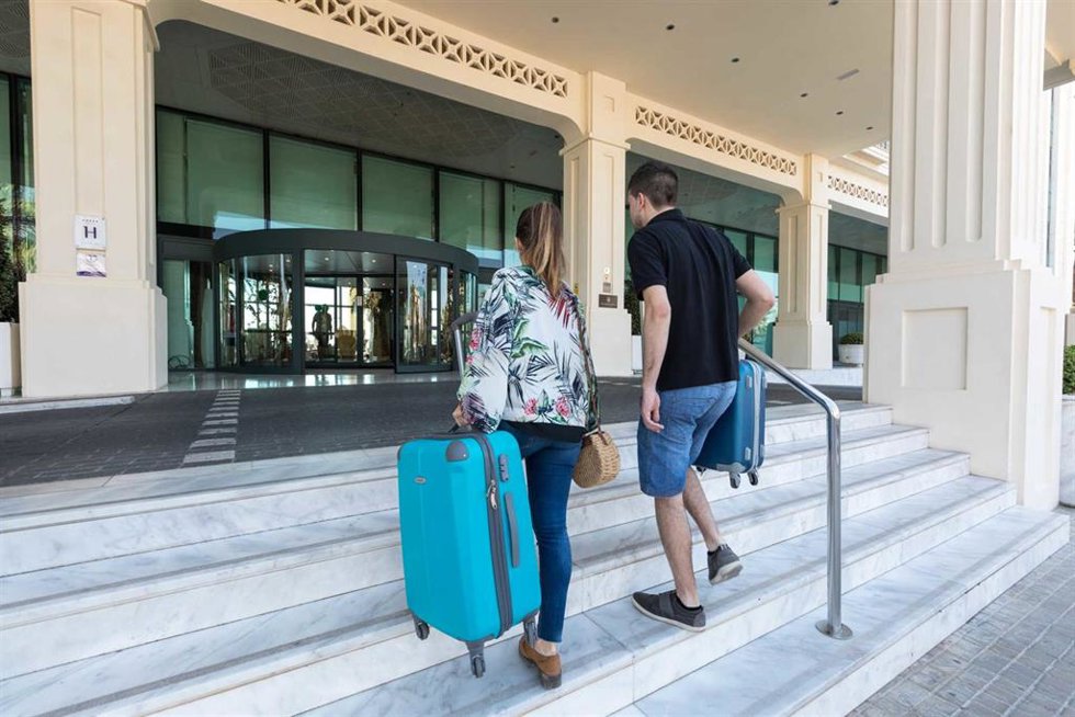 Archivo - Turistas entran en un hotel.