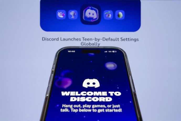 10 de fevereiro de 2026, Taichung, Taiwan: O aplicativo Discord é exibido no iPhone com sua página da web como pano de fundo. O Discord anunciou na segunda-feira que mudará todas as contas para configurações padrão para adolescentes, a fim de criar “uma e