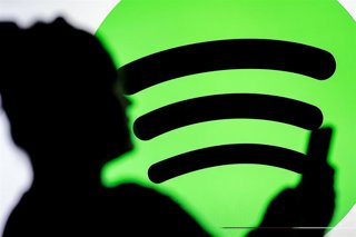 Archivo - Ilustración de un usuario junto al logo de Spotify.