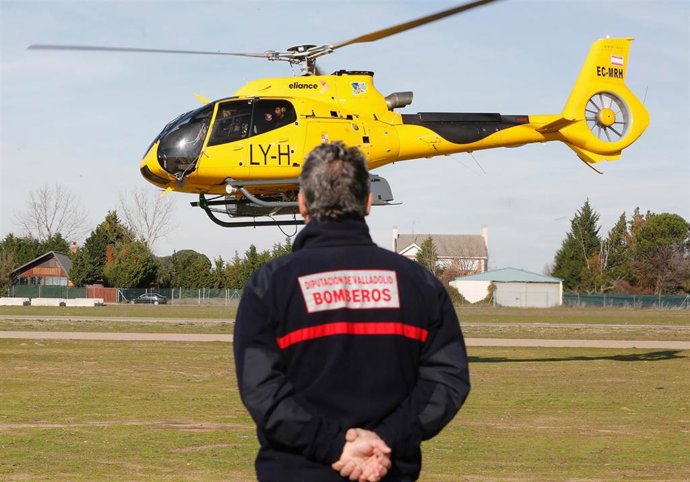 Archivo - Un miembro del efectivo de Bomberos de la Diputación de Valladolid observa un helicóptero de la Junta de Castilla y León que participa en la búsqueda de un ultraligero y a las dos personas que viajaban en él al norte y sur del río Duero, entre l