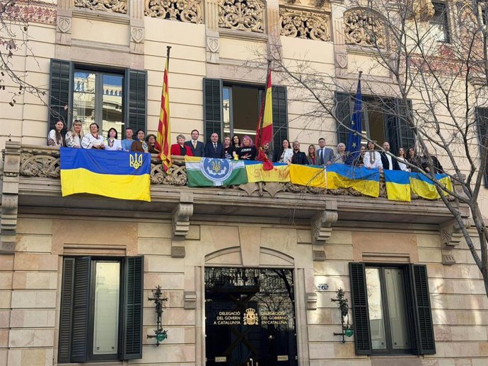 El delegado del Gobierno, Carlos Prieto, representantes consulares de Ucrania y miembros de la comunidad ucraniana desde el balcón de la Delegación del Gobierno en Barcelona