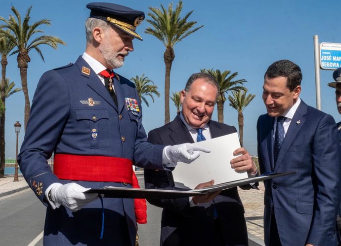 Felipe VI recibe una carpeta con fotos de La Rábida que había diseñado y traía en el tren María Clauss, fallecida en Adamuz. En la imagen, con el presidente de la Diputación de Huelva, David Toscano, y el presidente de la Junta, Juanma Moreno