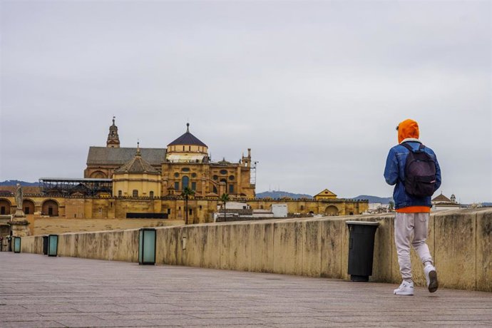Archivo - Transeúnte por el Puente Romano con vistas a la Mezquita-Catedral de Córdoba.