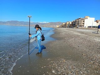 Técnica realiza mediciones topográficas en la orilla de la playa de Balerma, en El Ejido (Almería), tras los últimos temporales.