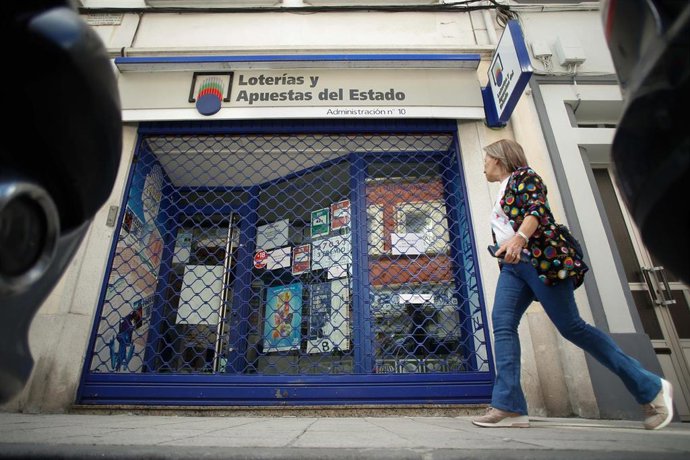 Archivo - Una mujer pasa por  Administración de loterías 