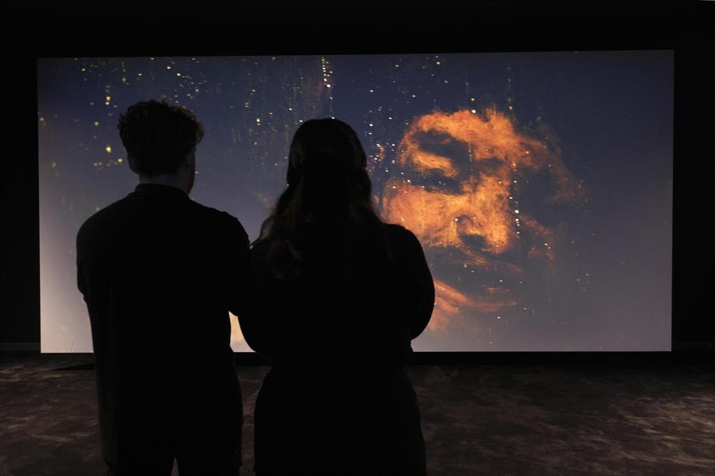 Dos personas contemplan uno de los fotogramas incluidos en la exposición.