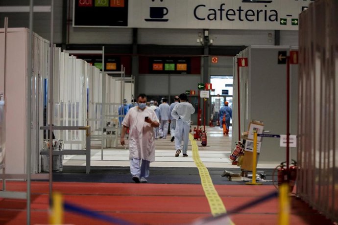 Archivo - Sanitarios caminan por el Pabellón 9 del hospital de campaña de IFEMA.