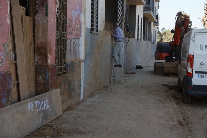 Archivo - Un hombre observa un edificio afectado por la DANA, a 28 de noviembre de 2024, en Paiporta.