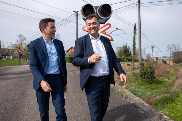 El delegado del Gobierno en Cantabria, Pedro Casares, y el alcalde de Marina de Cudeyo, Pedro Pérez, junto al paso a nivel de Orejo que va a eliminar Adif