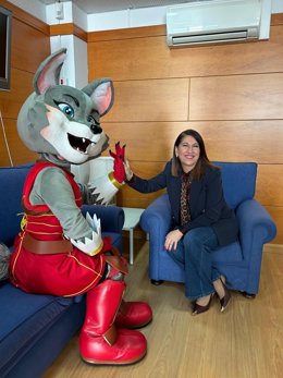 La mascota 'Luz' con la delegada de Turismo, Cultura y Deporte de la Junta de Andalucía en Huelva, Teresa Herrera.
