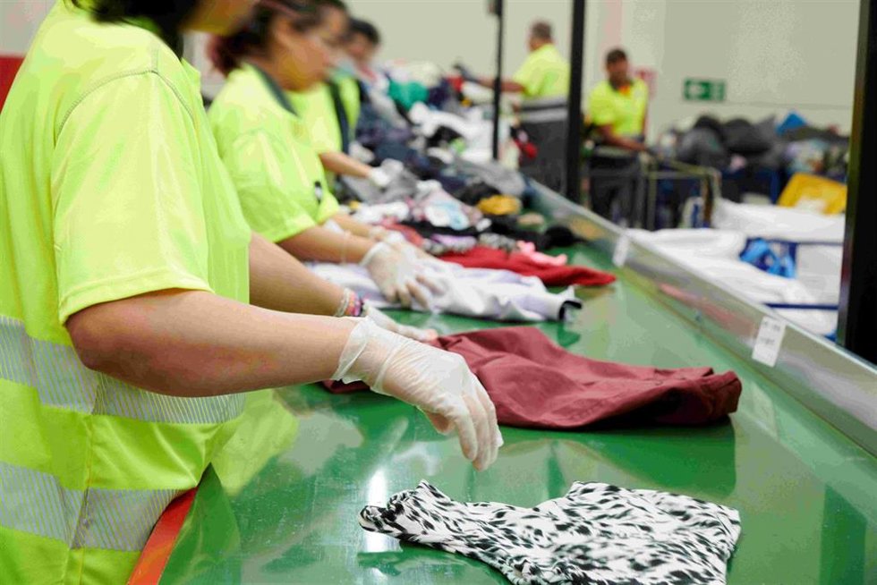 Trabajadores de la cooperatira Moda Re- seleccionan ropa.