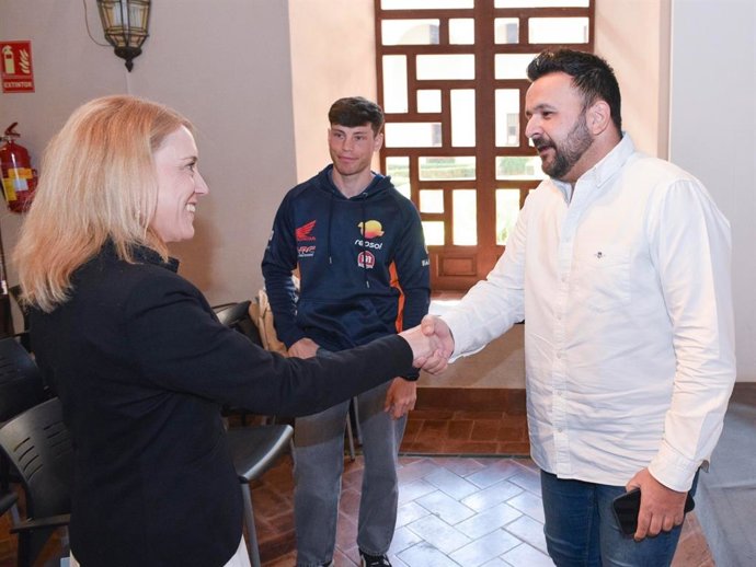 La delegada de Deportes, María Tena, saluda a uno de los responsables del Campeonato del Mundo de Trial en presencia de Gabriel Marcelli, piloto que representará a España en este evento.