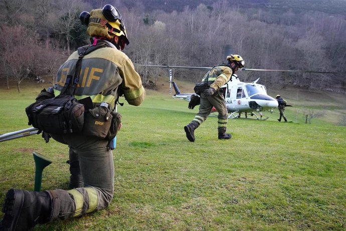 Archivo - Dos bomberos de las Brigadas de Refuerzo en Incendios Forestales (BRIF) de Cantabria y un helicóptero, trabajan en las labores de extinción de un incendio forestal en el valle de Ardisana, a 10 de marzo de 2023, en Llano, Asturias (España). El P