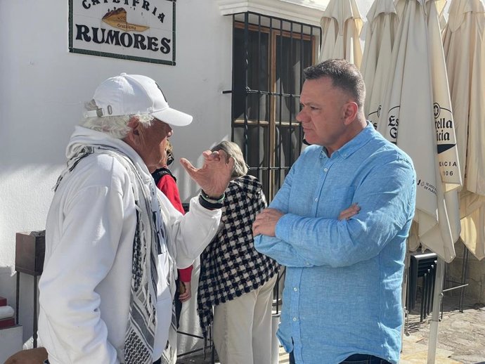 El candidato de Podemos Andalucía a la presidencia de la Junta de Andalucía, Juan Antonio Delgado, habla con un vecino durante una visita a la localidad de Grazalema (Cádiz)