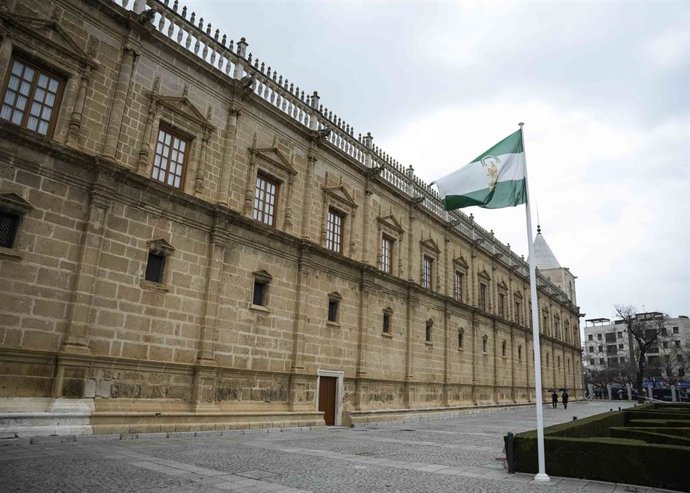 Archivo - La bandera de Andalucía ondea ante la fachada del Parlamento.