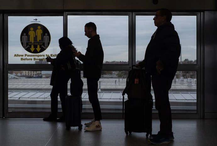 Archivo - Arquivo - 12 de novembro de 2025, Brooklyn, Nova York, EUA: Três viajantes com bagagem aguardam o AirTrain na plataforma Jamaica.