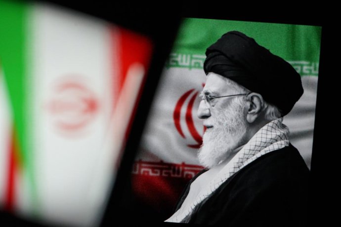 February 23, 2026, Turin, Turin, Italy: In this photo illustration, Iranian Supreme Leader Ayatollah Ali Khamenei is seen behind Iranian flag, with all of them displayed on screens, in Turin, Italy on February 23, 2026.