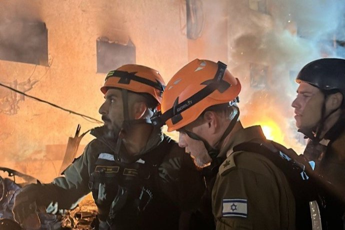 Treballadors dels serveis d'emergència d'Israel després de l'impacte d'un projectil iranià