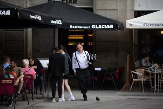 Archivo - Un camarero sostiene una bandeja en la plaza Real de Barcelona.