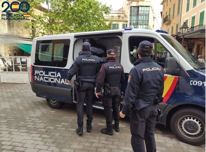 Agentes de la Policía Nacional frente a un furgón policial.