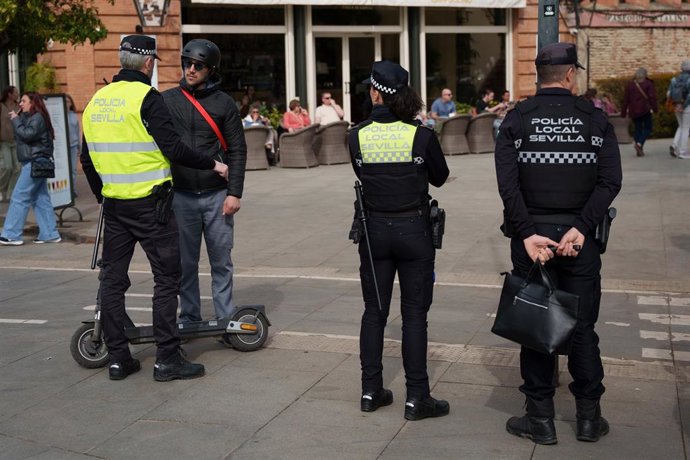 Agentes de la Policía Local de Sevilla informa a un usuarios de patinete eléctrico de la entrada en vigor de la normativa que regula su uso.