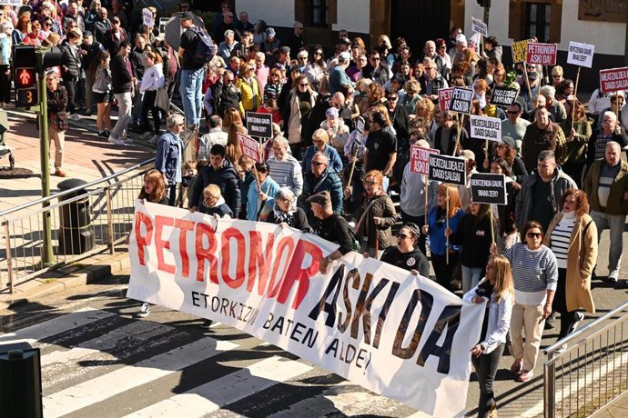 Manifestantes portan pancartas con lemas 'Petronor aski da' y 'Nos estáis matando' durante una manifestación para denunciar la fuga de benceno en una planta de Petronor, a 1 de marzo de 2026, en Abanto Zierbena y Muskiz
