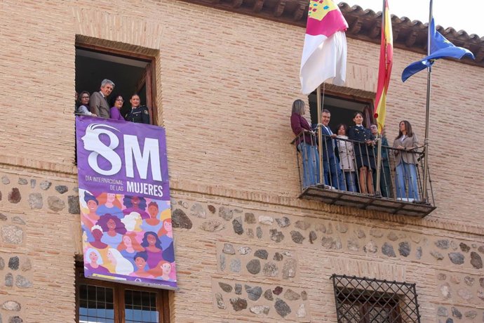 El delegado del Gobierno, José Pablo Sabrido, despliega en la fachada de la Delegación del Gobierno la pancarta con motivo del Día Internacional de las Mujeres.