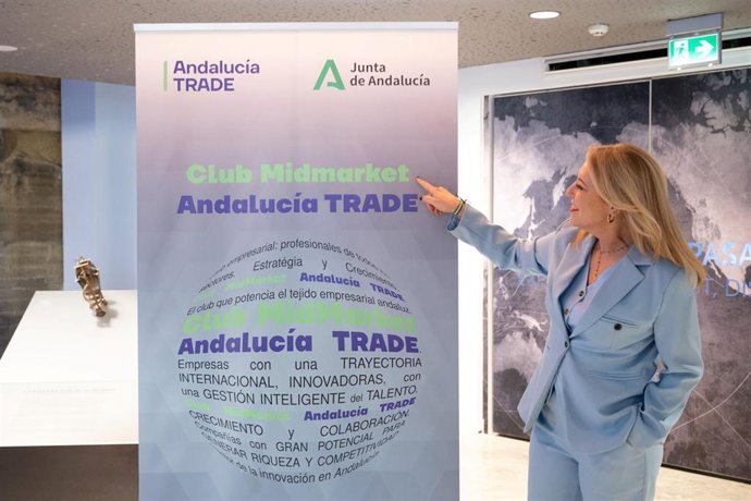 Imagen de la consejera de Economía, Hacienda, Fondos Europeos y Diálogo Social, Carolina España junto a un cartel de Club MidMarket Andalucía Trade.
