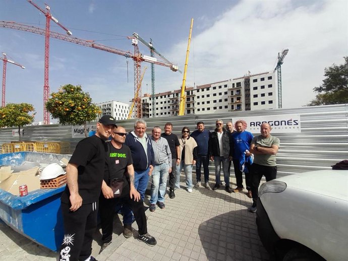 Gruistas en huelga, ante obras en Córdoba con grúas paradas.