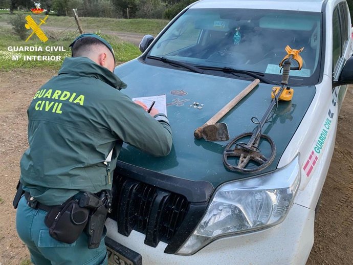 Un agente del Seprona junto a un detector de metales que estaba siendo utilizado sin autorización en La Puebla de los Infantes.