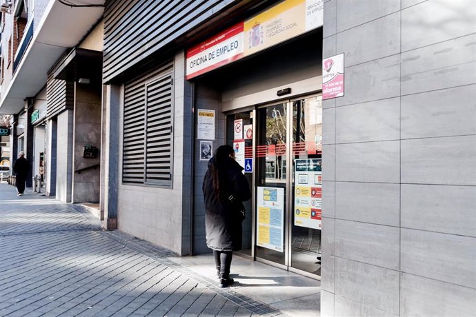 Archivo - Una mujer entra a una oficina del SEPE.