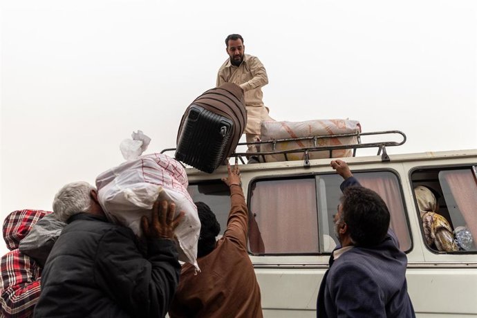 Archivo - Un hombre carga el equipaje y las pertenencias de afganos indocumentados en el techo de un vehículo cerca del cruce fronterizo de Milak, en la provincia de iraní de Sistán-Baluchestán, antes de su repatriación voluntaria a Afganistán