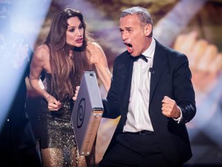 Carlos Lozano celebrando su victoria en 'GH DÚO' con el maletín del premio en la mano ante la atenta mirada de Cristina Piaget