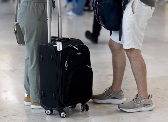 Archivo - Varias personas con maletas, en el Aeropuerto Adolfo Suárez Madrid-Barajas