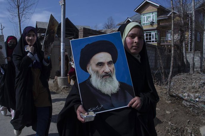 Archivo - Imagen de una adolescente con un retrato del ayatolá Alí Sistani, la máxima autoridad religiosa chií en Irak.