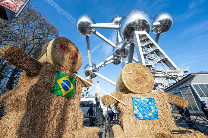Archivo - Dos muñecos de paja con las banderas de Brasil y la Unión Europea en una protesta frente al Atomium de Bruselas contra el acuerdo comercial con Mercosur